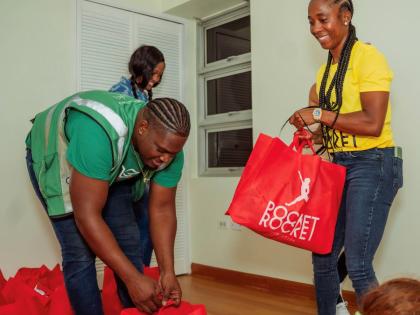 Shelly-Ann Fraser-Pryce (right), founder of the Pocket Rocket Foundation, joins volunteers last Friday in assembling care packages for families impacted by Hurricane Melissa. The initiative forms part of the Foundation’s national relief drive to support 