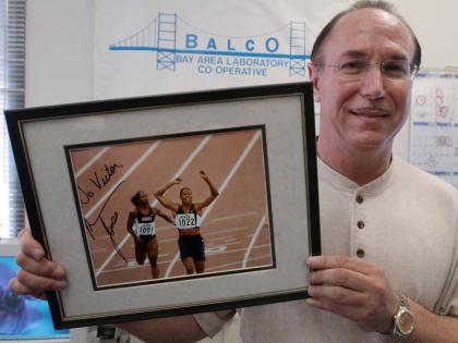 BALCO founder Victor Conte holds up an autographed photo of track star Marion Jones addressed to him in his office in Burlingame, California, on October 21, 2003. 