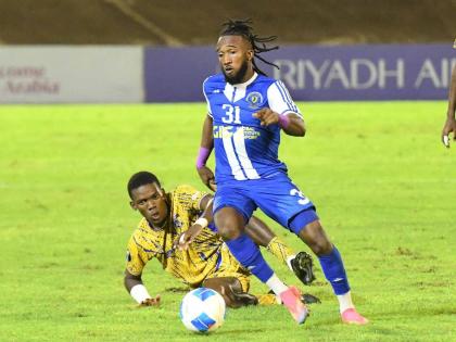 Mount Pleasant Football Academy’s Demario Phillips dribbles away from Defence Force’s Kaihim Thomas during their Concacaf Caribbean Cup football match at the National Stadium in Kingston last night. Defence Force of Trinidad and Tobago won 1-0. Mount P