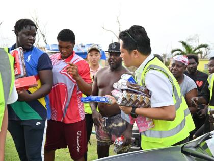Businessman Yucheng Tao (right) is seen distributing care packages to residents of Shrewsbury Logwood in Westmoreland.