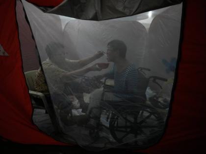 Judy Bertuso (left) feeds her husband Apollo inside a tent at an evacuation centre as Typhoon Fung-wong entered the country on Sunday, November 9 in Quezon city, Philippines.