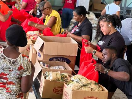 Volunteers from JMMB and the Council of Voluntary Services prepare care packages for distribution to communities impacted by Hurricane Melissa.