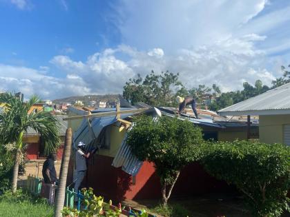 Volunteers fix a classroom roof damaged by Hurricane Melissa.