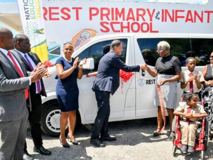 Ambassador of Japan to Jamaica,  Yasuhiro Atsumi, hands over the keys for a bus to principal of the Clarendon-based Rest Primary and Infant School, Sandra Smith, during a ceremony held at the institution.