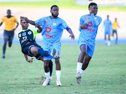 Giovanni Taylor (left) of Jamaica College attempts a shot at goal as Romaine Walters (centre) and Tchane Riley (right) of St Catherine High  try to stop him. The action is from the Jamaica College versus St Catherine High Manning Cup semi-final played at t