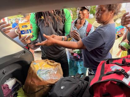 Dr Aujae Dixon hands out relief supplies to residents on one of the stops of the medical mission. The team has so far visited communities in Hanover and Westmoreland.