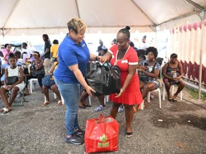 State Minister in the Ministry of Health and Wellness, Krystal Lee (left), hands over a care package to expecting mother Shanae Cooper-Robinson during a maternal health outreach at the Black River Health Centre in St Elizabeth on November 21.