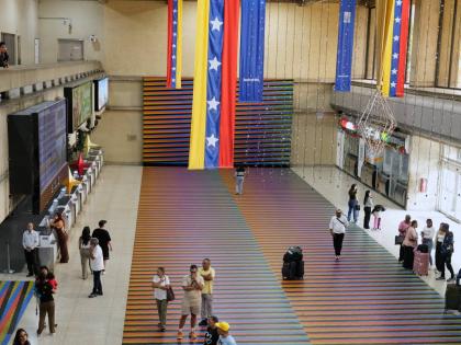 Travellers wait in the main hall of the Simon Bolivar Maiquetia International Airport in Maiquetia, Venezuela, Sunday, November 23, 2025, after several international airlines cancelled flights following a warning from the US Federal Aviation Administration
