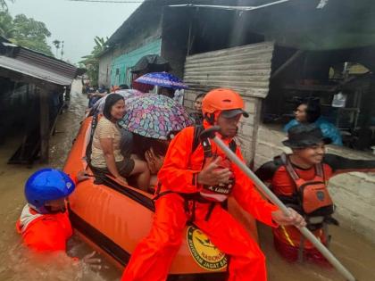 In this photo released by the Indonesian National Search and Rescue Agency (BASARNAS), rescuers on a rubber boat evacuate residents from their flooded home in North Sumatra province, Indonesia Tuesday, November 25, 2025. (BASARNAS via AP)