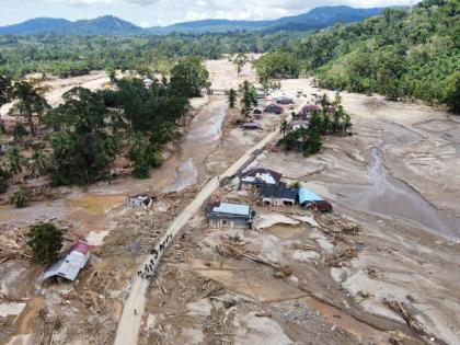 People walk along a road in a village affected by a flash flood in Batang Toru, North Sumatra, Indonesia on December 1, 2025. 