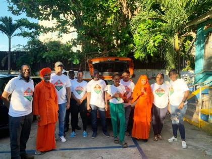 Members and volunteers of the Ananda Marga pose for a photograph as they prepare to head out to distribute relief supplies to people affected by Hurricane Melissa in western Jamaica.