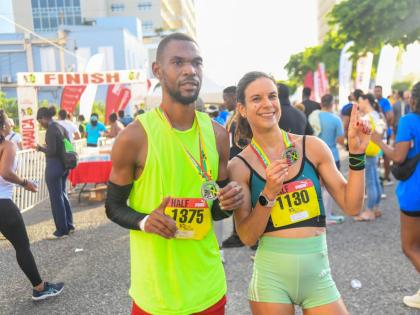 Garfield Gordon (left) and Cecile Heinrich pose with their medals after topping the men’s and women’s half marathon event, respectively, at the 2026 Reggae Marathon in downtown Kingston yesterday. 
