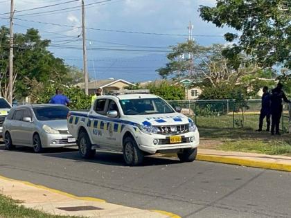 Police at the scene of an alleged shoot-out in Phoenix Park Village, St Catherine in which an alleged robber was fatally shot.