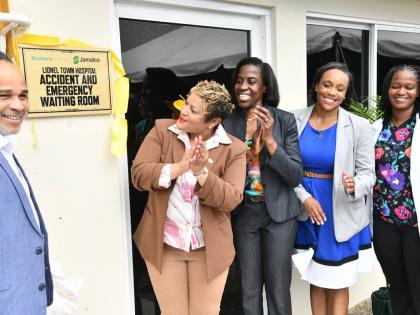 Minister of State in the Ministry of Health and Wellness, Krystal Lee (second left), applauds as she views the plaque dedicating the newly renovated Accident and Emergency Waiting Area at the Lionel Town Hospital in Clarendon, at the official opening of th