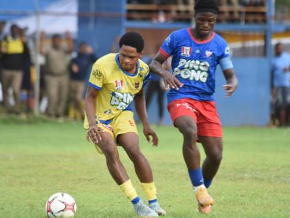 St Elizabeth Technical High School’s Jade Lynch (left) tries to shake off the attention of Kemps Hill High School’s Shemar Daley during a testy round-of-16 ISSA daCosta Cup clash at STETHS Sports Complex on October 22.