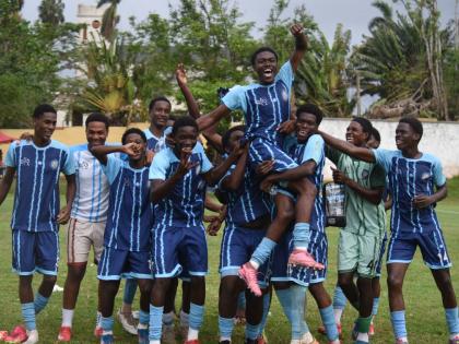 Manning’s School players hold substitute player Jordan Turner aloft in celebration of the part he played in a 2-1 victory over Christiana High in the ISSA Ben Francis Cup quarter-final football game at the Manchester High playing field yesterday.
