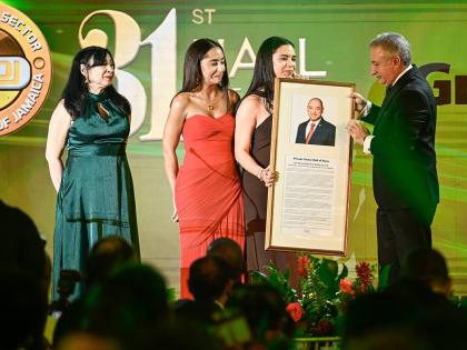 Daughters of the late Don Wehby, Stephanie (second left) and Abigail, accept a plaque from President, Private Sector Organisation of Jamaica, Metry Seaga, inducting Wehby in the PSOJ 31st Hall of Fame on Monday. Sharing in the moment is Wehby’s sister, D
