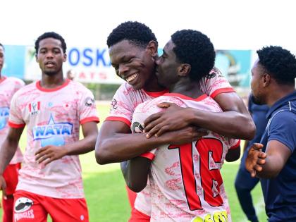 Mona High School’s Franklyn Mitcham (centre) celebrates scoring in a Walker Cup semi-final against Charlie Smith High School at the Anthony Spaulding Sports Complex yesterday.