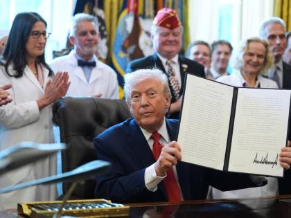 United States President Donald Trump displays an executive order reclassifying marijuana as a less dangerous drug in the Oval Office of the White House on December 18, 2025.