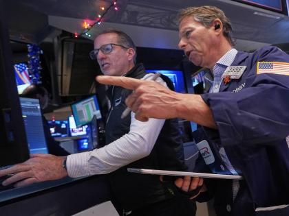 AP 
Specialist Glenn Carell, left, and trader Robert Charmak work on the floor of the New York Stock Exchange. 