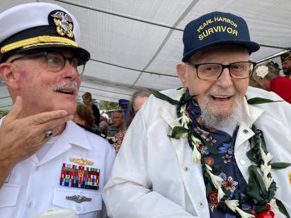 Ira Schab (right) who survived the attack on Pearl Harbor as a sailor on the USS Dobbin, talks with reporters while sitting next to his son, retired Navy Commander Karl Schab, in December 2022, in Pearl Harbor, Hawaii. 