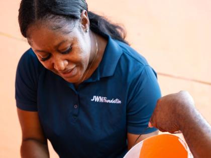 Keliesha Fearon, a resident of St Elizabeth and a JWN Foundation volunteer, prepares paint to help with the rebuilding efforts.