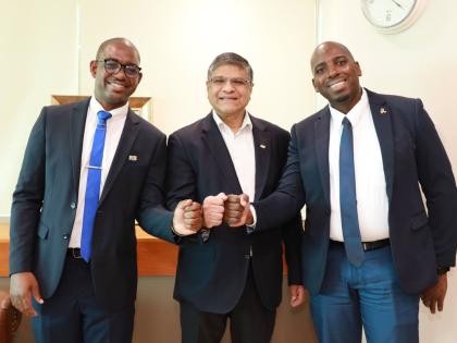 Robert Almeida, CEO of NCB Financial Group Limited (centre), shares a moment with Maurice Dawson (left), customer care agent, and Cordell Brown, business banker at NCB Fairview Financial Centre, before surprising them with a Grant a Wish donation to help c