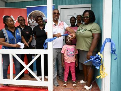 VM Group Chairman Michael McMorris (centre) cuts the ribbon to officially hand over a new two-bedroom home to Novia Russell (right) and her children (second to fourth right) Javon, Danique and Zaliyah. Also present are (from left) Kivette Silvera, executiv