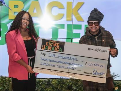 Music executive, Portia Clarke-Mellanaise and reggae and R&B star, Maxi Priest, display a symbolic cheque made out to the JN Foundation to assist in its Hurricane Melissa relief efforts. The funds were raised through the staging of the ‘For the Love of J