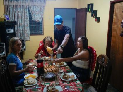 Mariela Gómez (right) and her partner Abraham Castro, a migrant couple, sit for Christmas dinner at Castro’s parents’ home in Maracay, Venezuela.