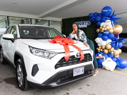 Carrie Davis, English Language teacher at Vere Technical High School, poses with her brand-new 2025 Toyota RAV4 during the official handover ceremony held on December 23, 2025, at Toyota Jamaica.