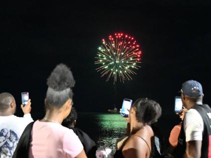 Residents watch as fireworks light up the seafront for the first time in Black River, St Elizabeth, during the New Year’s fireworks show staged by the Urban Development Corporation.