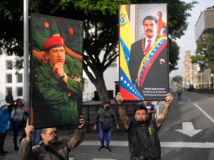 Government supporters display posters of Nicolás Maduro, right, and Hugo Chávez in downtown Caracas, Venezuela.