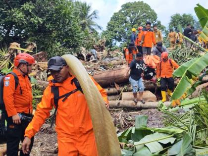 In this photo released by the Indonesian National Search and Rescue Agency (BASARNAS) on Tuesday, January 6, 2026, rescuers and villagers search for victims after flash floods hit Sitaro district of North Sulawesi province, Indonesia. (BASARNAS via AP)