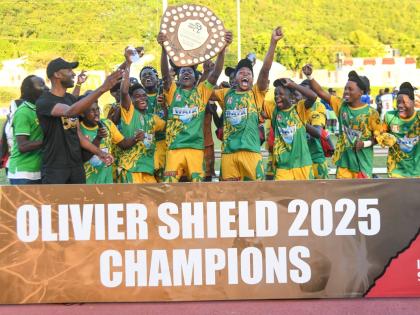 
Members of the Excelsior High School football team celebrate with the Olivier Shield after their 2-0 win over St Elizabeth Technical High School at the Stadium East field yesterday. 