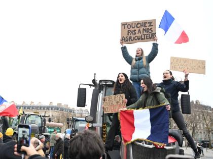Women atop a tractor support farmers as they protest at the Arc de Triomphe against the European Union's negotiations over the Mercosur trade deal with five South American nations.