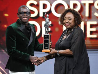 Oblique Seville receives the RJRGLEANER Sportsman of the Year award from Olivia ‘Babsy’ Grange, minister of culture, gender, entertainment and sport, during the RJRGLEANER National Sports Award on Saturday at the TVJ Studios.