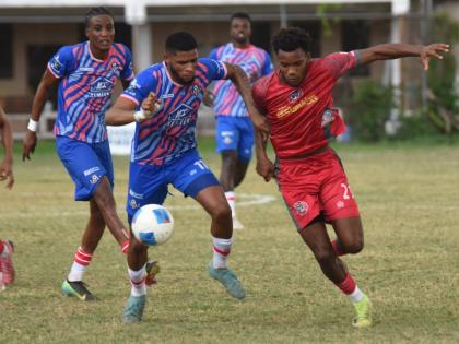 Portmore United’s Gawain Austin (left) and Montego Bay United’s Richardo Ramsey battle for the ball during their Jamaica Premier League game at Jarrett Park in Montego Bay yesterday. The game ended 0-0.