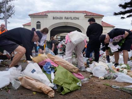 Workers gather floral tributes, messages of support and items left as a memorial is dismantled in Sydney, Monday, December 22, 2025, a week after an attack on a Jewish festival that left 15 dead. (AP Photo/Rick Rycroft)