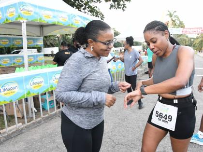 Claudine Allen, general manager of the JN Foundation (left), has a conversation with Dandie Williams, from the Pacers Running Club, who was the first woman to complete the JN Group Race for Hope 5K at Hope Gardens on Sunday.