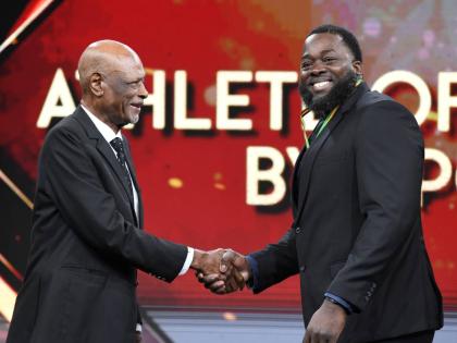Chad Wright, 2025 Weightlifting Athlete of the Year (right), collects his award at the RJRGLEANER National Sports Award at TVJ Studios on Sunday from George Campbell, General Manager, Coldfield Manufacturing/Pure Country.