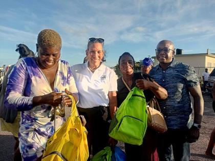 Colleen Wint-Bind (second left), project coordinator at the Violence Prevention Alliance (VPA), presents care packages to parents at Rocky Point in Clarendon at a community outreach activity organised by the VPA. Sharing in the moment is Pearnel Charles Jr