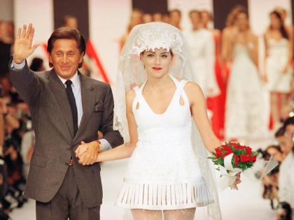 Valentino Garavani waves to the public and holds by the hand American actress Sharon Stone wearing the wedding gown at the end of the presentation of Valentino’s 1994 Spring/Summer ready-to-wear collection presented in Paris October 13, 1993. 