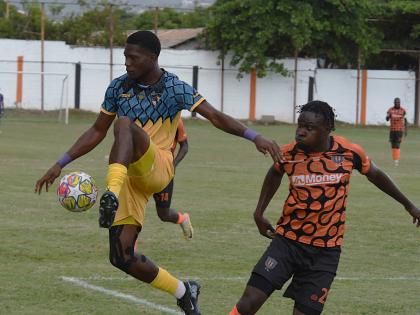 Racing United’s Jimoy Jones (left) intercepts a pass aead of Tivoli Gardens’ Dayne Ewen during their Jamaica Premier League football match at the Edward Seaga Stadium yesterday. The game ended 0-0.