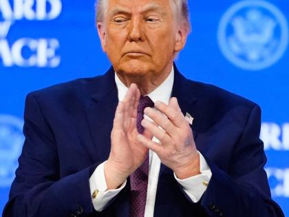 President Donald Trump applauses during a signing ceremony on his Board of Peace initiative at the Annual Meeting of the World Economic Forum in Davos, Switzerland, Thursday, January 22, 2026. (AP Photo/Markus Schreiber)