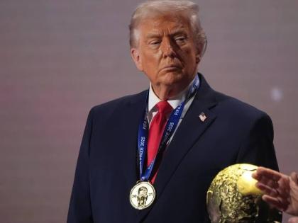 President Donald Trump stands on stage next to the FIFA World Cup after receiving the FIFA Peace Prize during the draw for the 2026 World Cup at the Kennedy Center in Washington, Friday, December 5, 2025.  