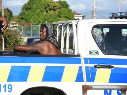 US-based Reggae Boy Corey Burke is taken away by members of the  Jamaica Constabulary Force outside the Ferdi Neita Park yesterday. Burke was detained following an altercation at the entrance to the  venue which was hosting the Portmore United versus Racin