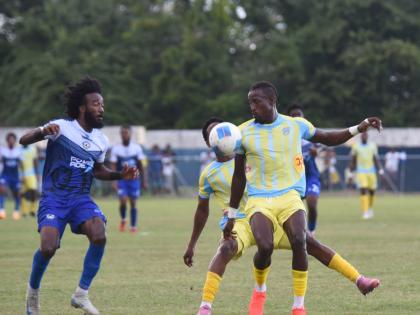 Waterhouse FCs Javane Bryan (right) tries to get past Mount Pleasant Academy’s Demario Phillips (left) during their Jamaica Premier League game at Drax Hall Sports Complex in St Ann yesterday.