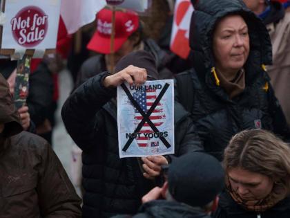 A man holds a map of Greenland covered in the American flag crossed out with an X during a protest against Trump’s policy towards Greenland in front of the US consulate in Nuuk, Greenland, Saturday, January 17, 2026. 