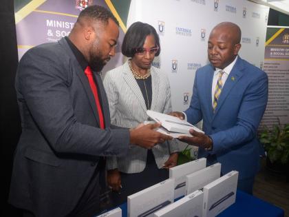 Minister of Labour and Social Security, Pearnel Charles Jr. (right), receives two of the 200 tablet computers donated to the Ministry by the Universal Service Fund (USF) from Chief Executive Officer, Charlton McFarlane. The presentation took place during a